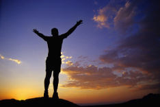 This image shows a man rejoicing atop a mountain. Finding a job can seem like a massive challenge but by improving your skills you too can be successful